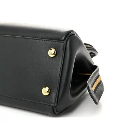 Black Small Madrid bag corner with gold stud and attached shoulder strap detail.