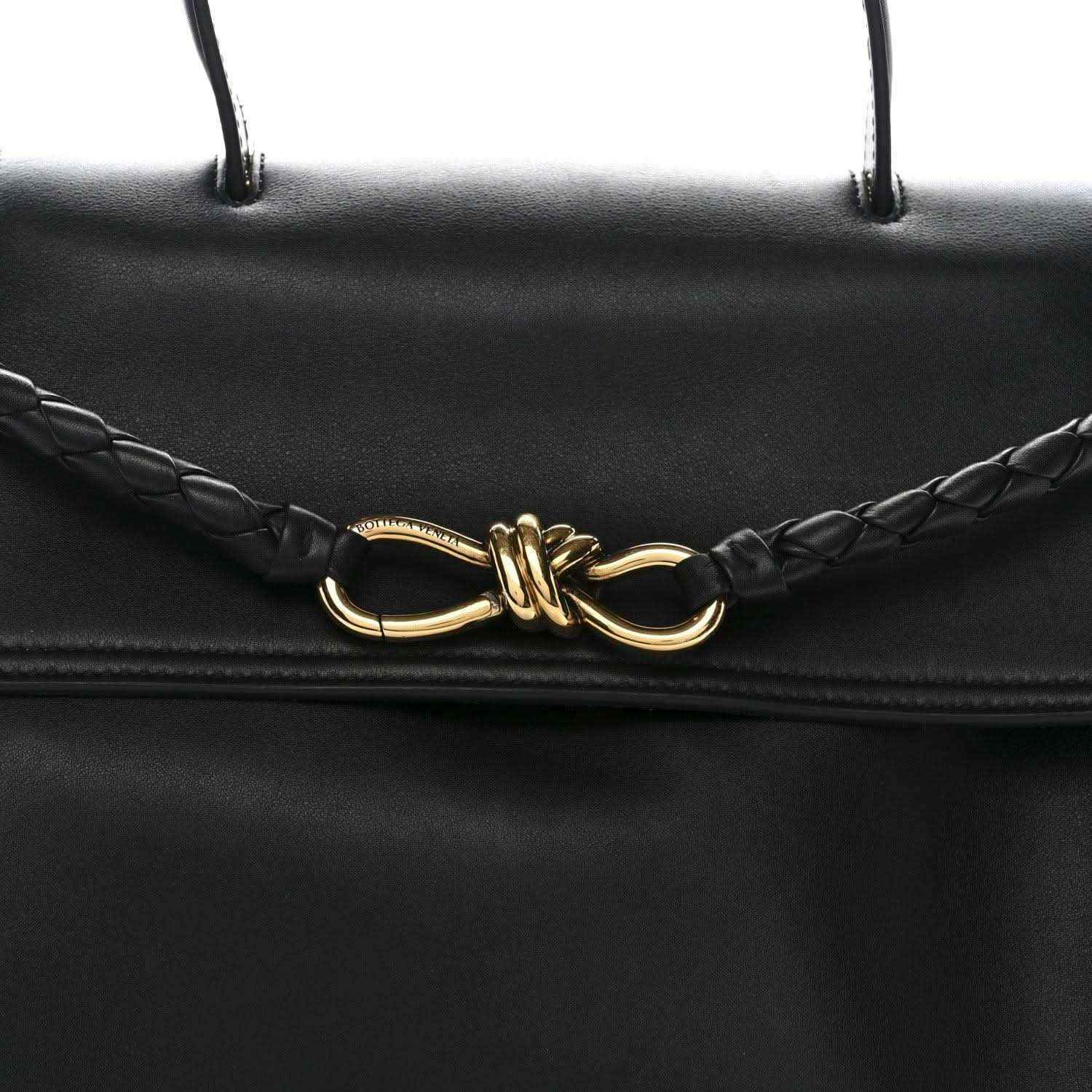 Black leather Ciao Ciao shoulder bag front clasp detail with braided cords and gold hardware.