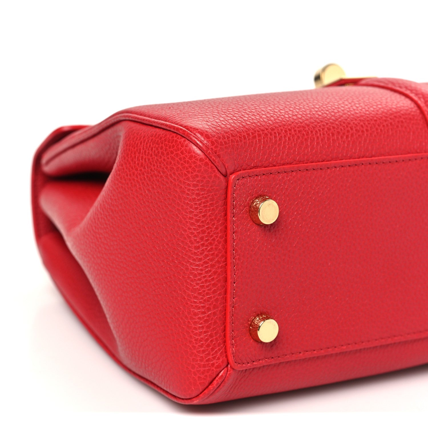 Celine red bag corner with gold snaps and pebbled leather texture.