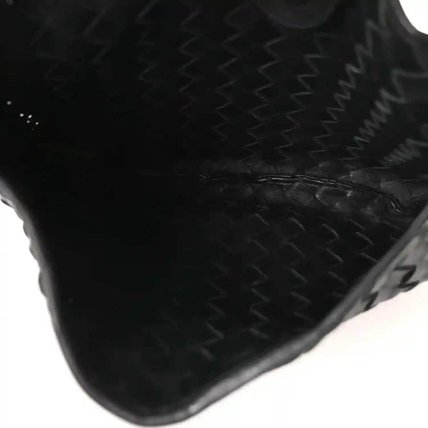 Bottega Veneta intrecciato nappa leather corner in black with woven texture close-up.