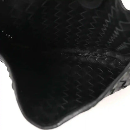 Bottega Veneta intrecciato nappa leather corner in black with woven texture close-up.