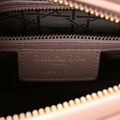 Handbag interior leather label with embossed branding under gold zipper trim