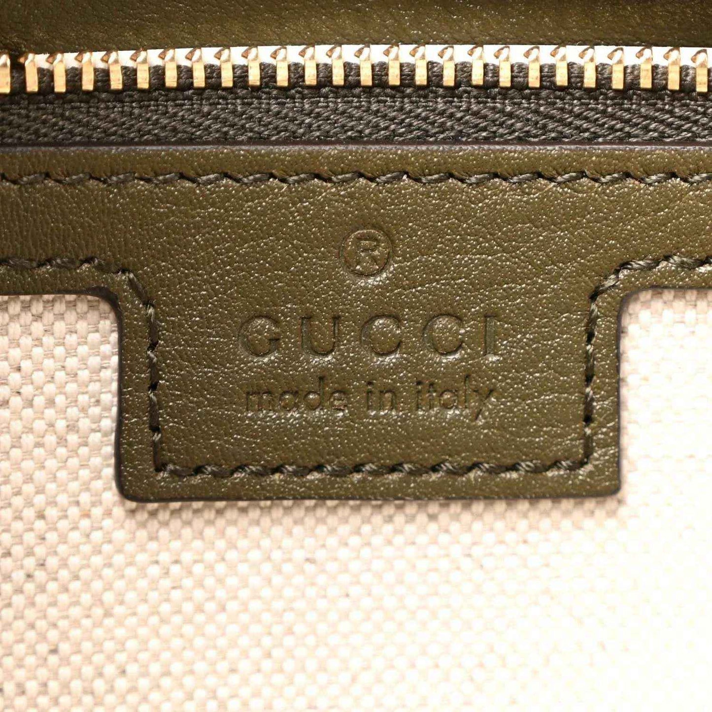 Gucci logo patch detail on green leather handbag with stitched border