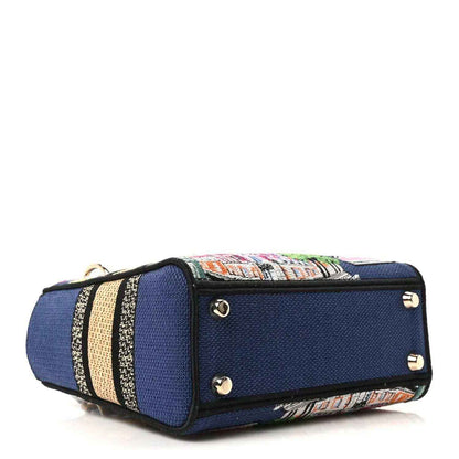Blue small handbag with striped embroidered trim, top tab, and metal stud details