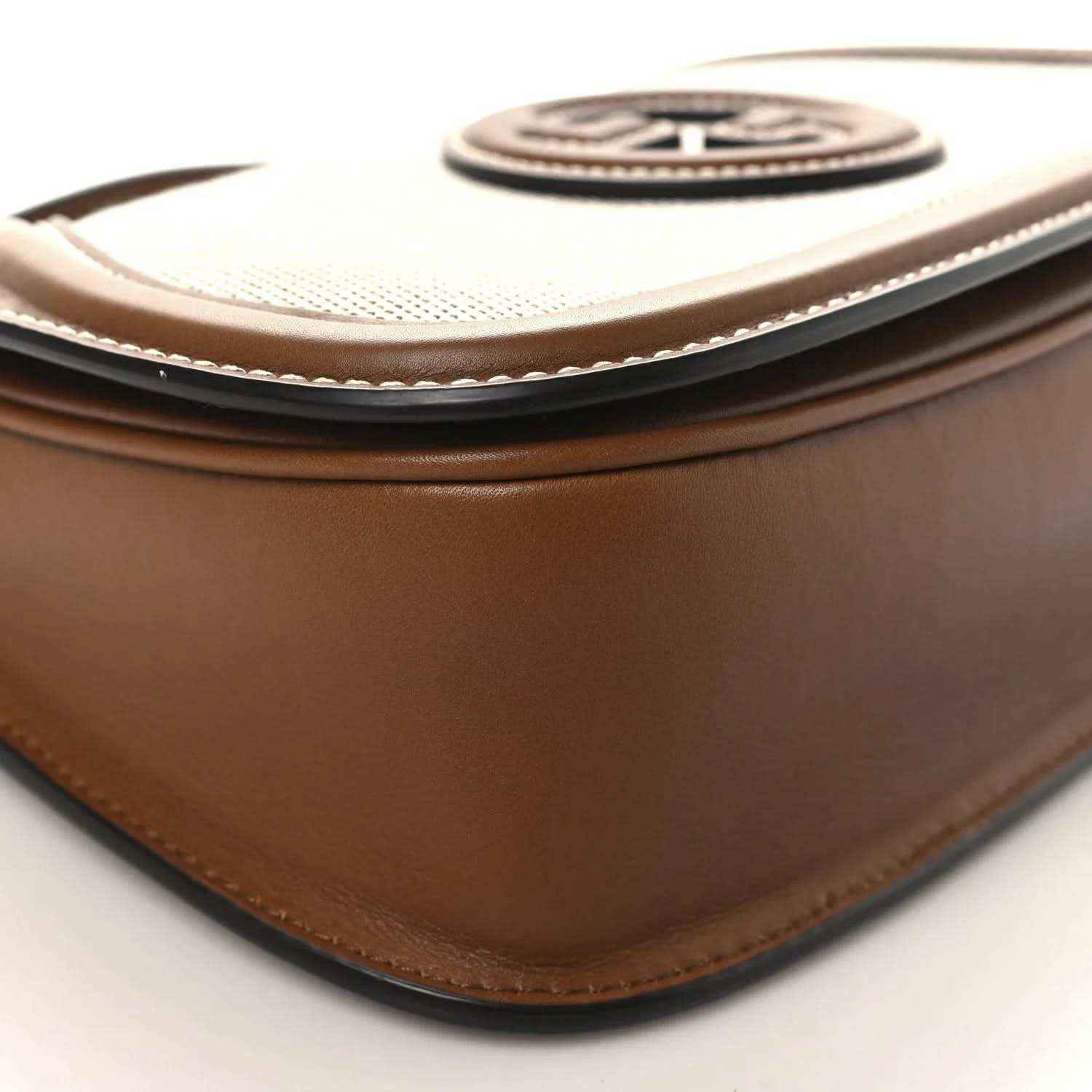 Brown leather corner with stitched piping and GG logo medallion on beige canvas