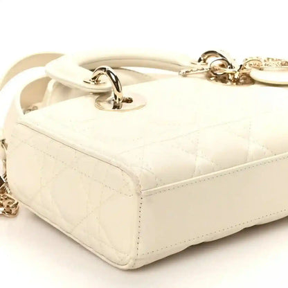 Small white quilted handbag with side handle rings and gold-tone latch