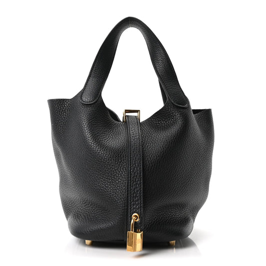 Black pebbled leather tote bag with top handles and front zipper with gold clasp