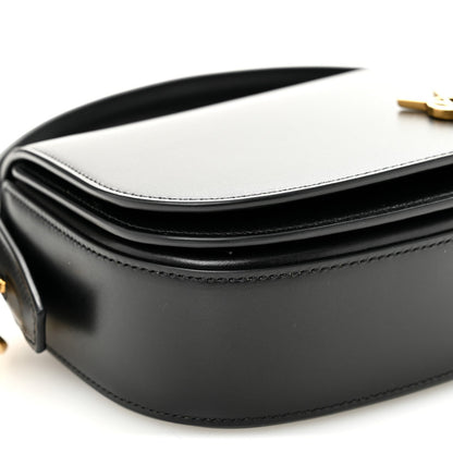 Bicolor leather crossbody bag detail with white flap, black body, and YSL clasp.
