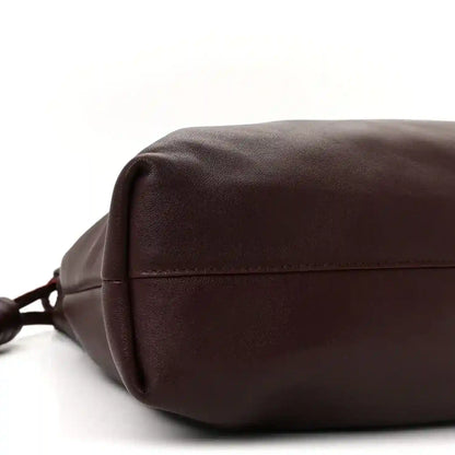 Dark burgundy leather clutch with top flap and ruched seam