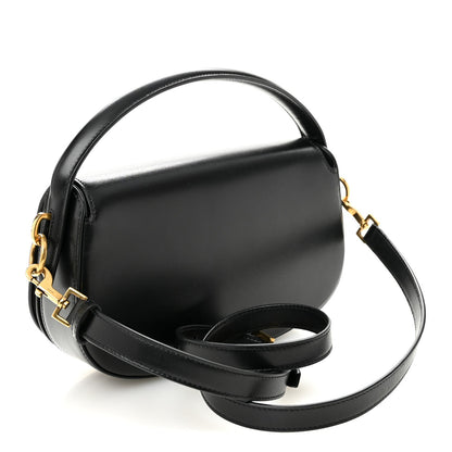 Black crossbody bag with top handle and long strap, gold hardware and YSL logo charm.