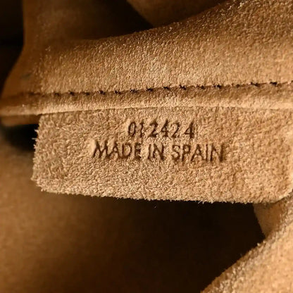 “Made in Spain” stamp on suede lining inside tan clutch