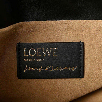 Black leather clutch label reading “LOEWE” and “Made in Spain” with signature