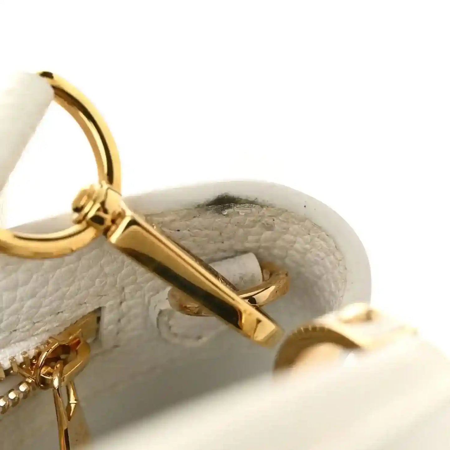 White leather bag interior with gold clasp bar and ring hardware