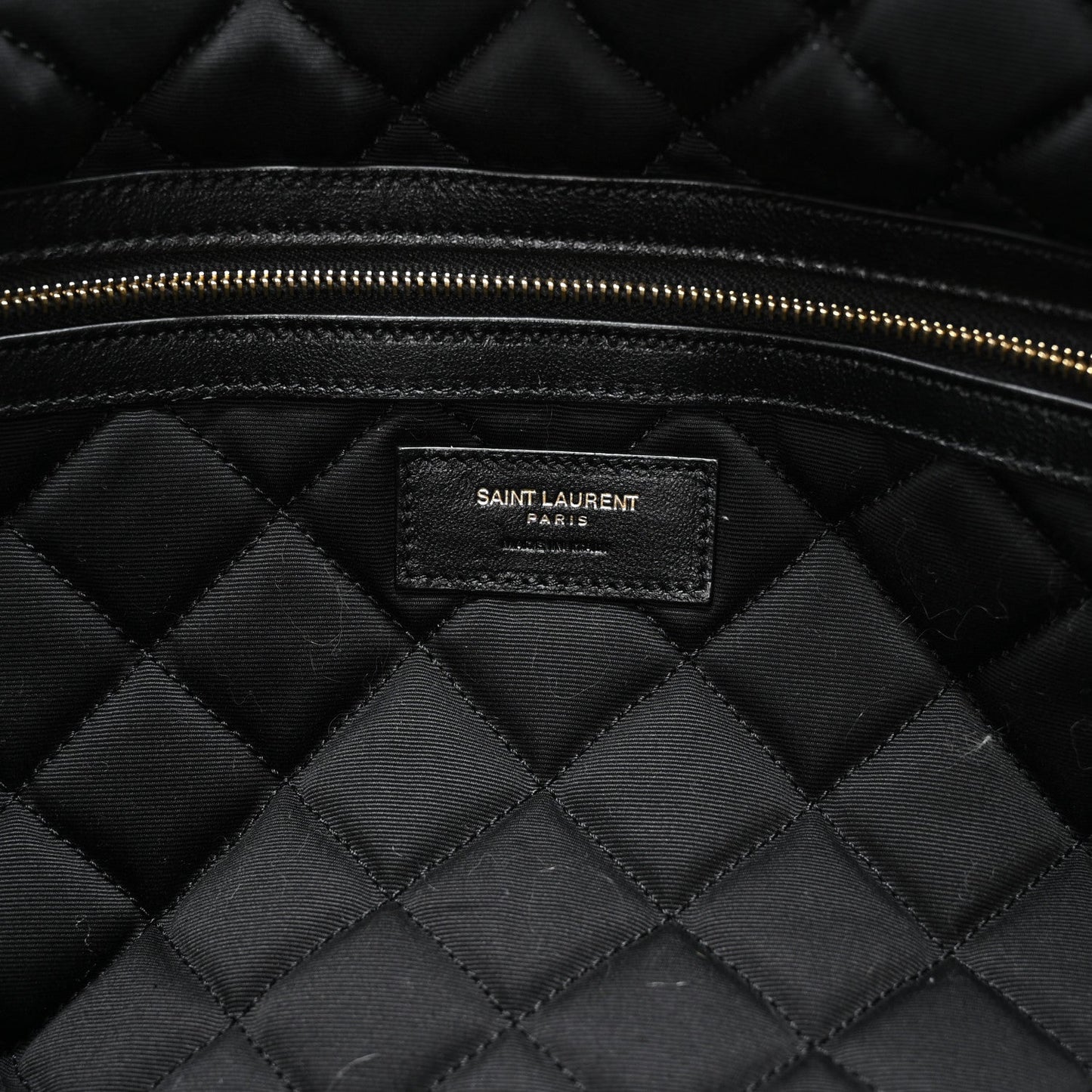 Black quilted lining with Saint Laurent PARIS brand patch and gold zipper