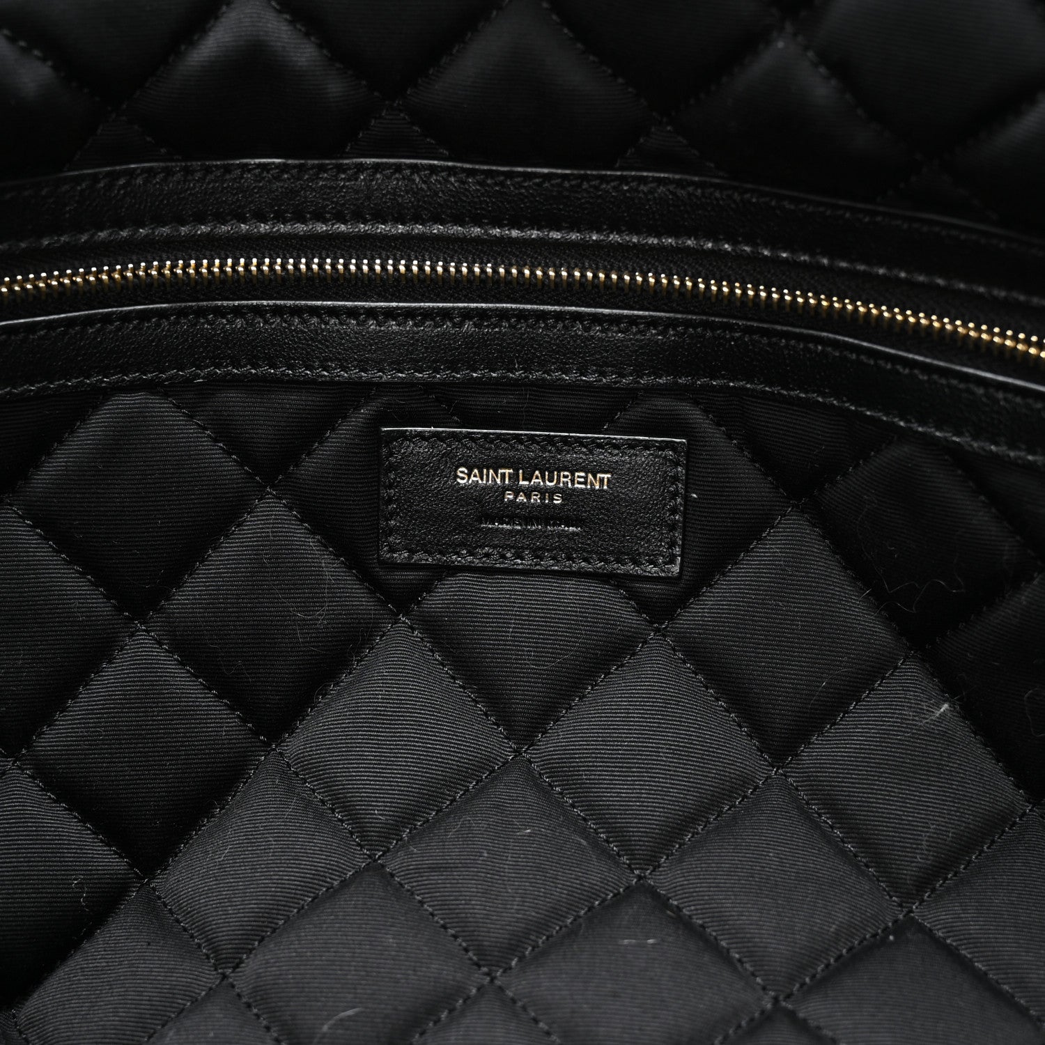 Black quilted lining with Saint Laurent PARIS brand patch and gold zipper