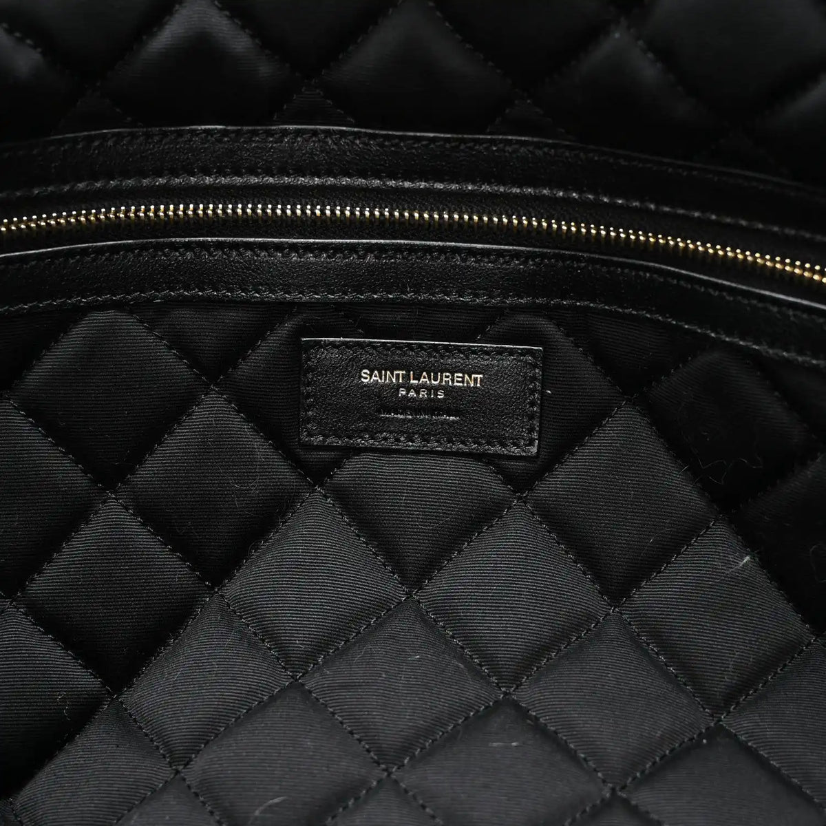 Black quilted lining with Saint Laurent PARIS brand patch and gold zipper