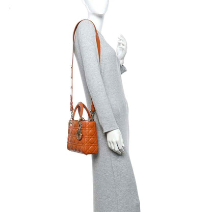 Small Lady Dior tote worn on a grey dress with orange quilted lambskin and top handle