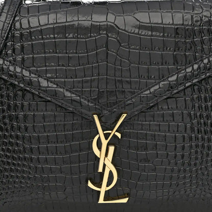 Black crocodile-embossed bag front with gold YSL logo clasp