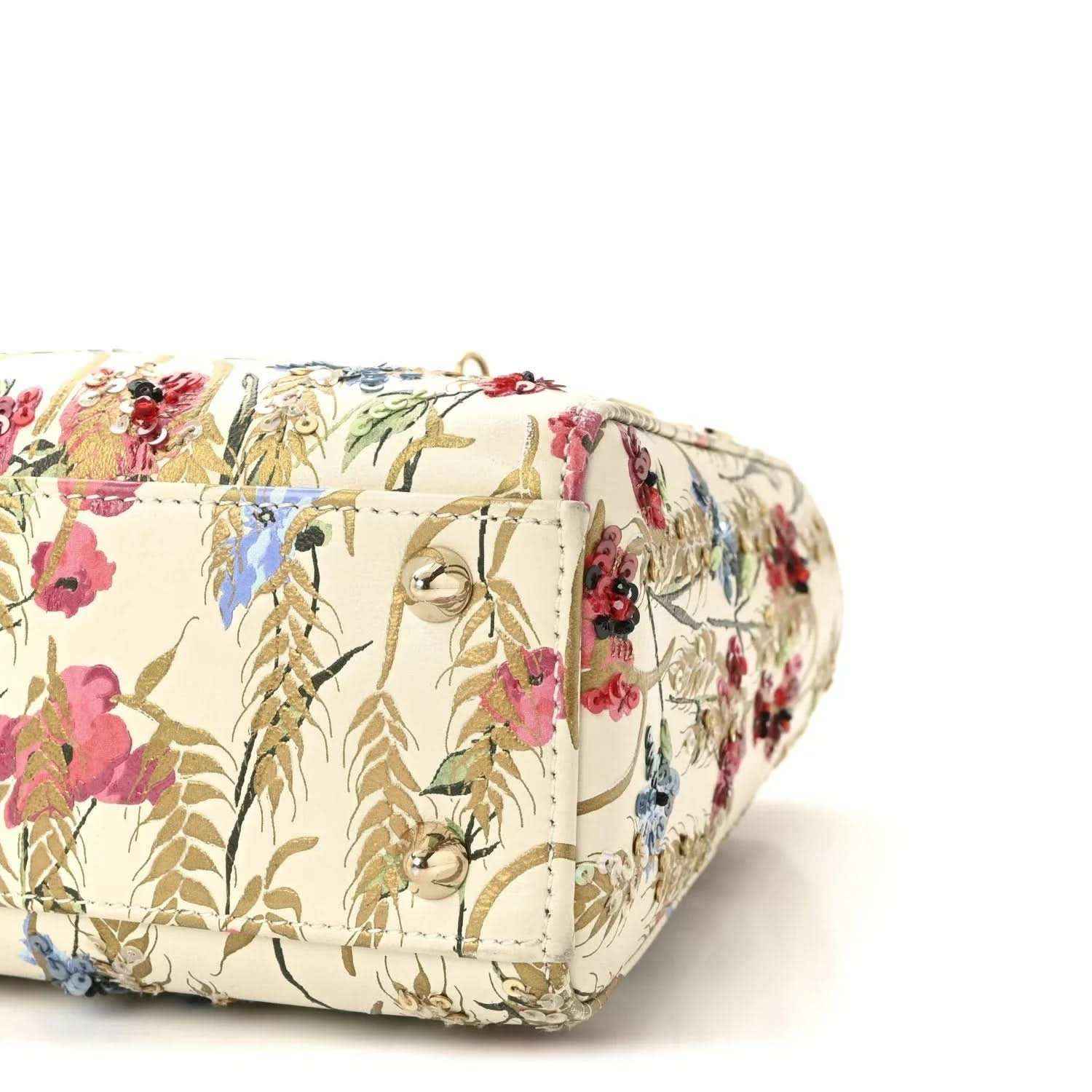 Embroidered floral tote with snap pocket detail and cream cylindrical base