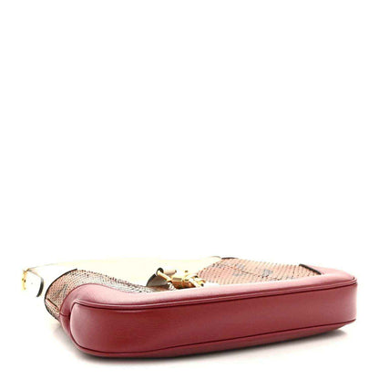 Small hobo bag side view with pink leather base and beige snakeskin panel.