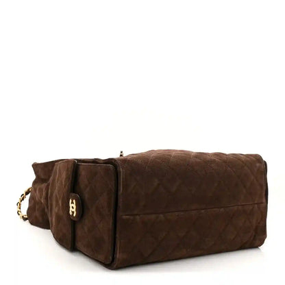 Dark brown suede quilted handbag with chain shoulder strap and rounded top