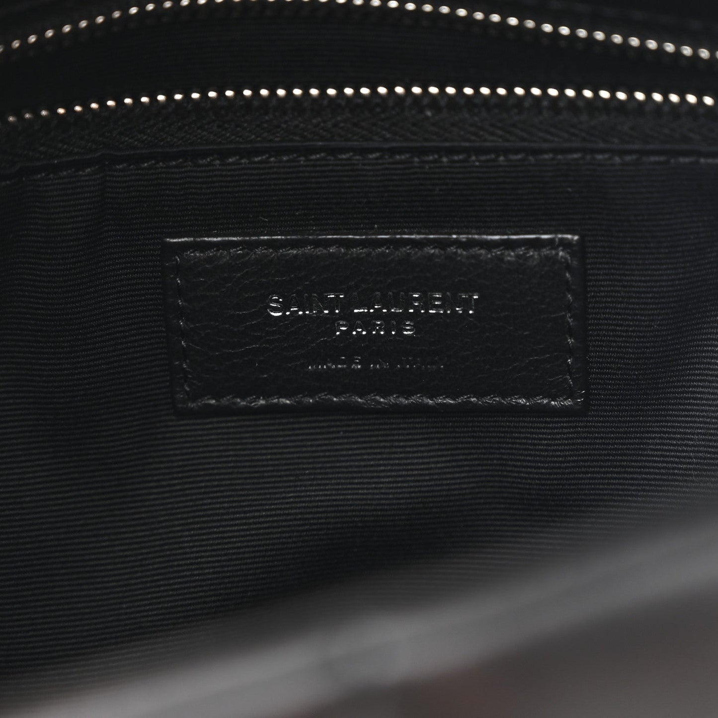 Black satin-lined interior pocket with stitched leather brand label inside satchel.