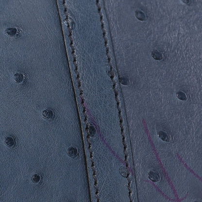 Blue ostrich leather side panel with visible stitching along the seam.