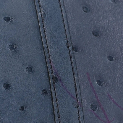 Blue ostrich leather side panel with visible stitching along the seam.