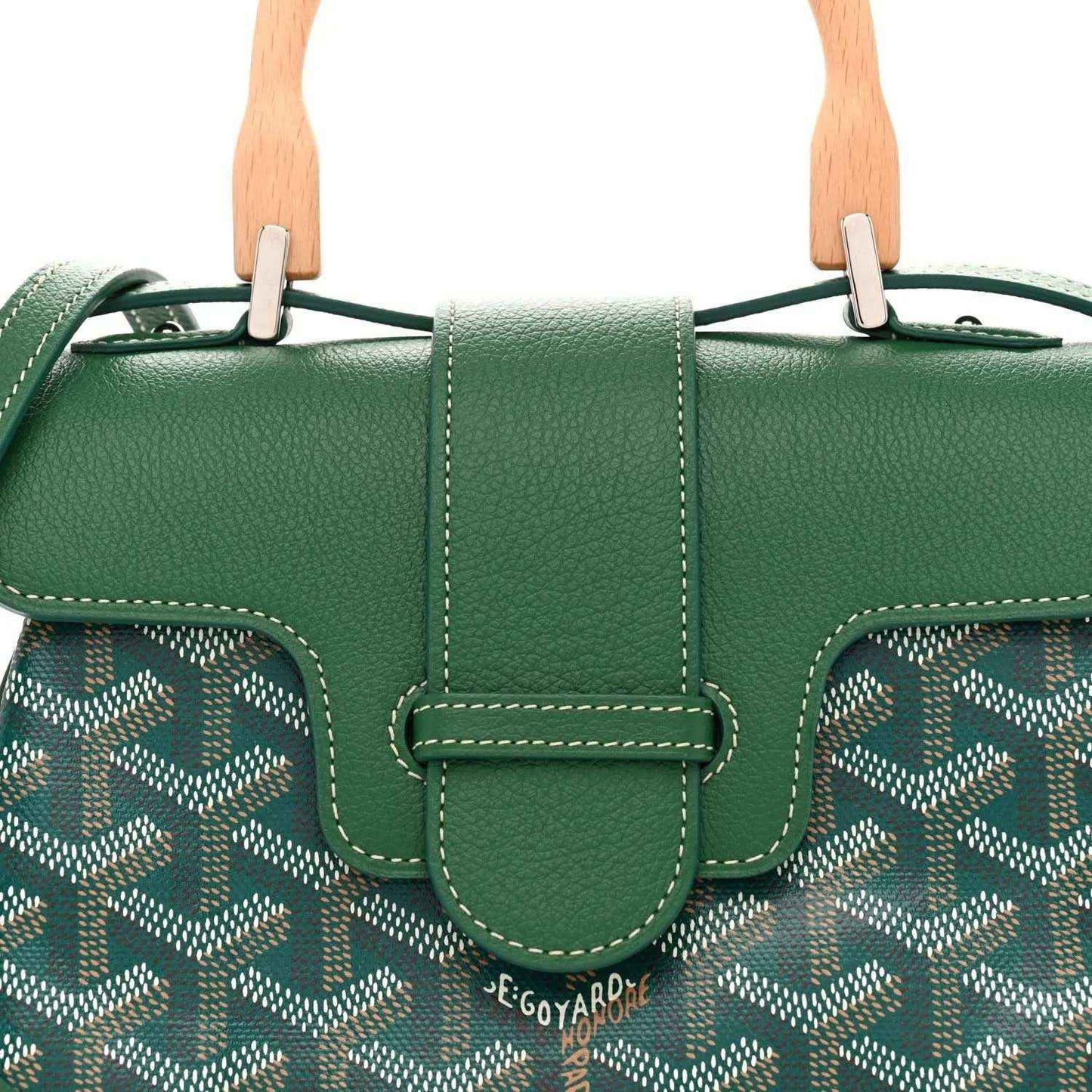 Close-up of green flap and center buckle on the mini Saigon bag over chevron canvas
