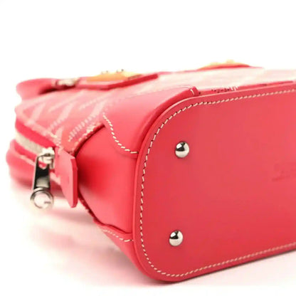 Red mini handbag side view with zipper pull, stitched trim, and silver stud details