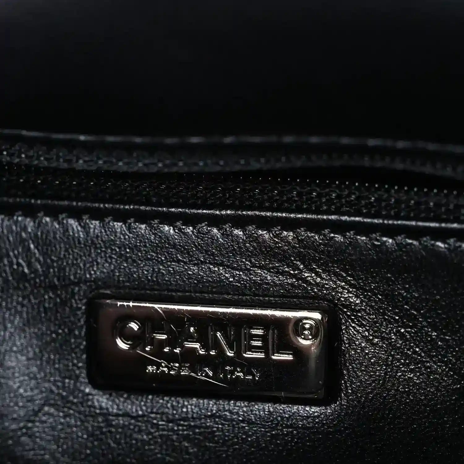 Black satin lining with Chanel logo plaque at inner side seam
