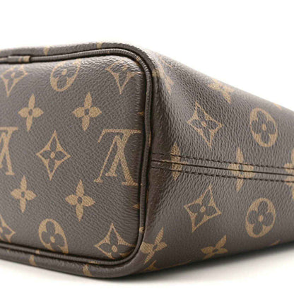 Monogram pouch corner close-up with black trim, stitched seams, and brown patterned canvas