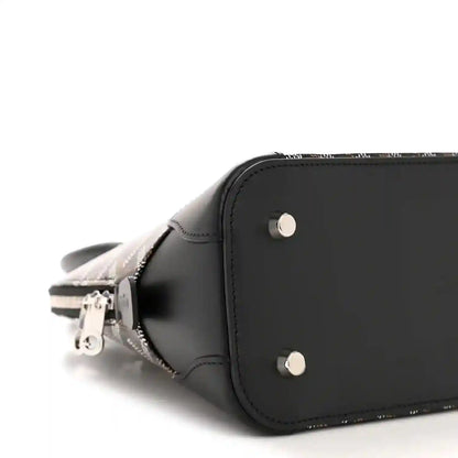Black mini bag side view with silver rivets, smooth leather edge, and zipper pull