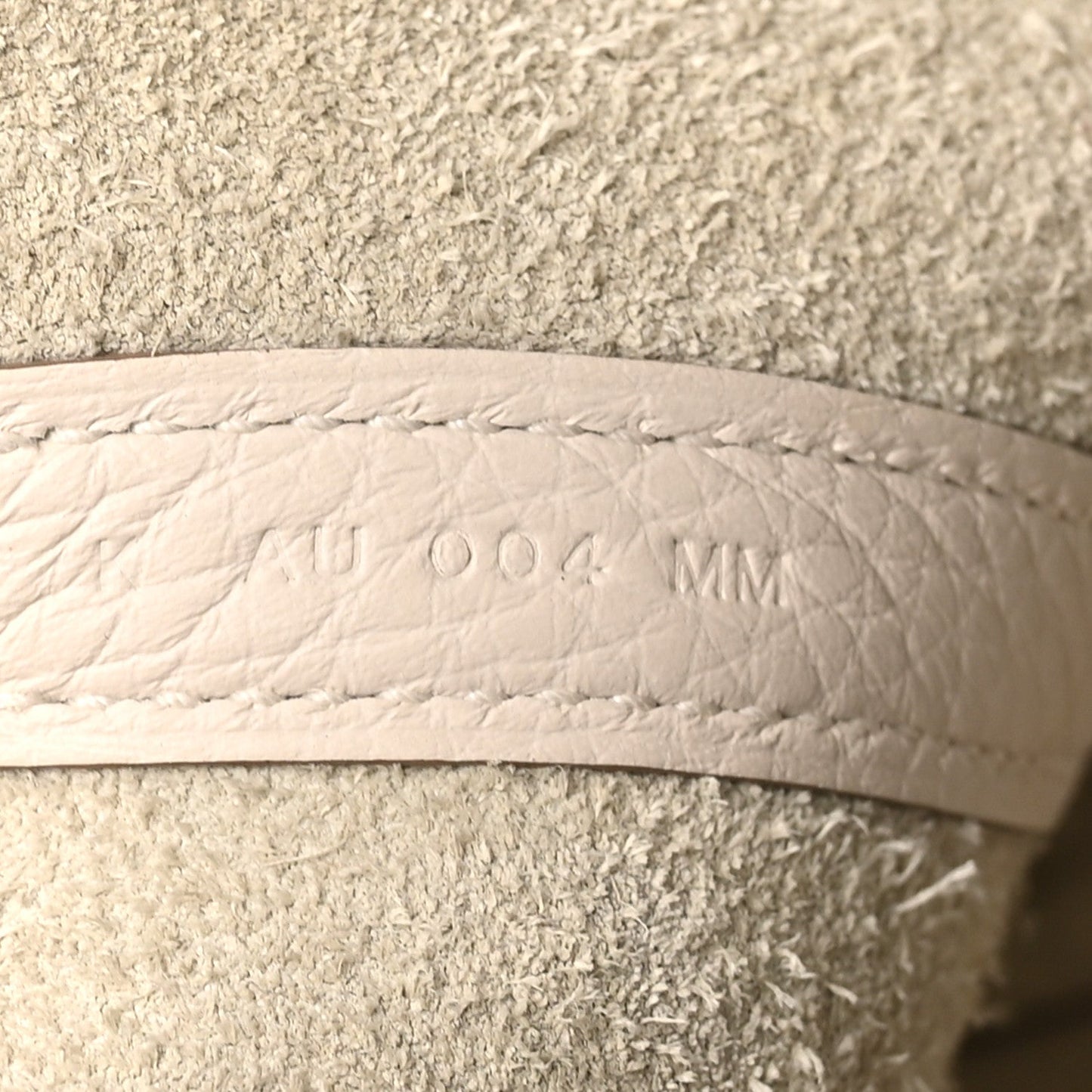 Pale cream leather lining with embossed size marking, side panel close-up