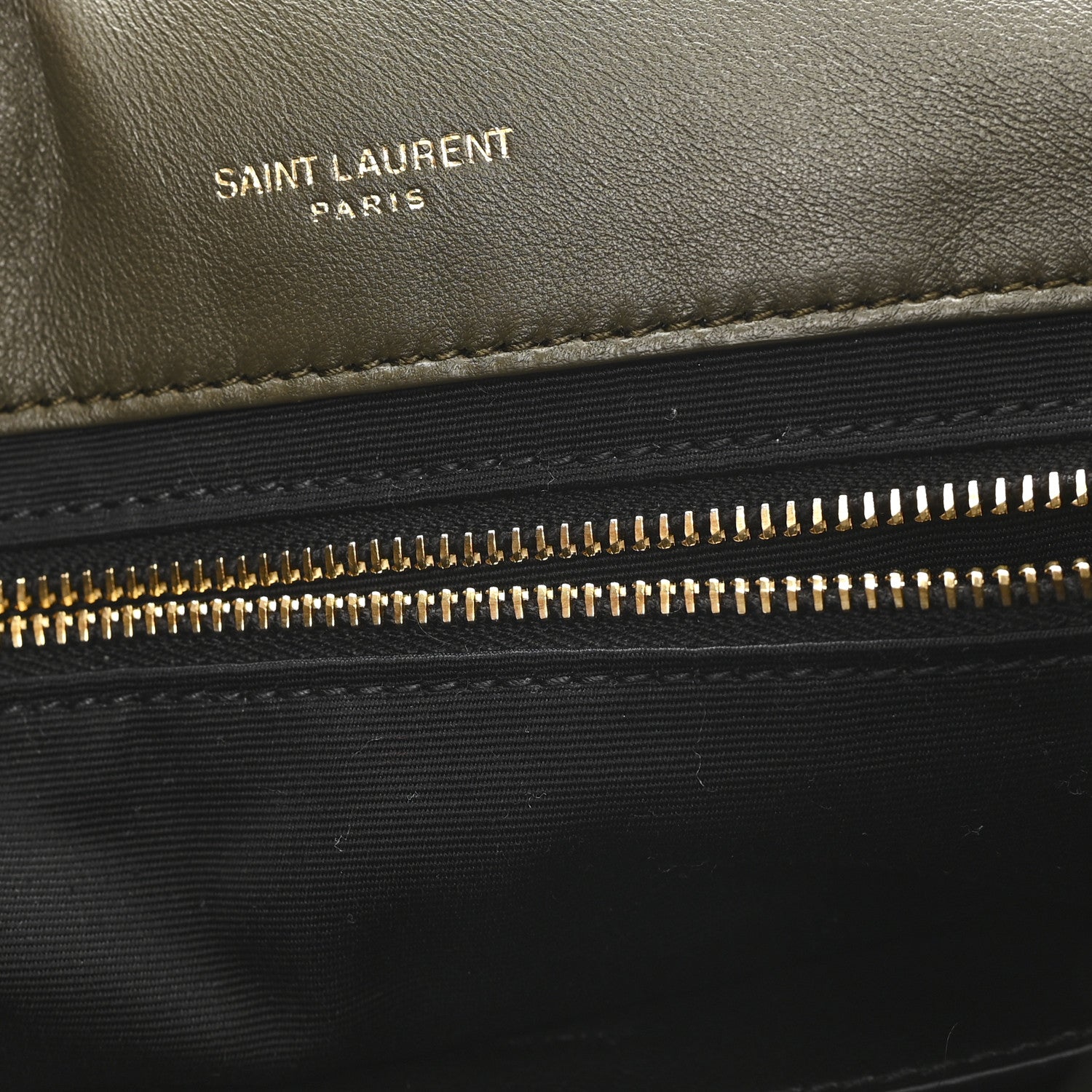 Black leather shearling bag panel with “SAINT LAURENT PARIS” text and zipper