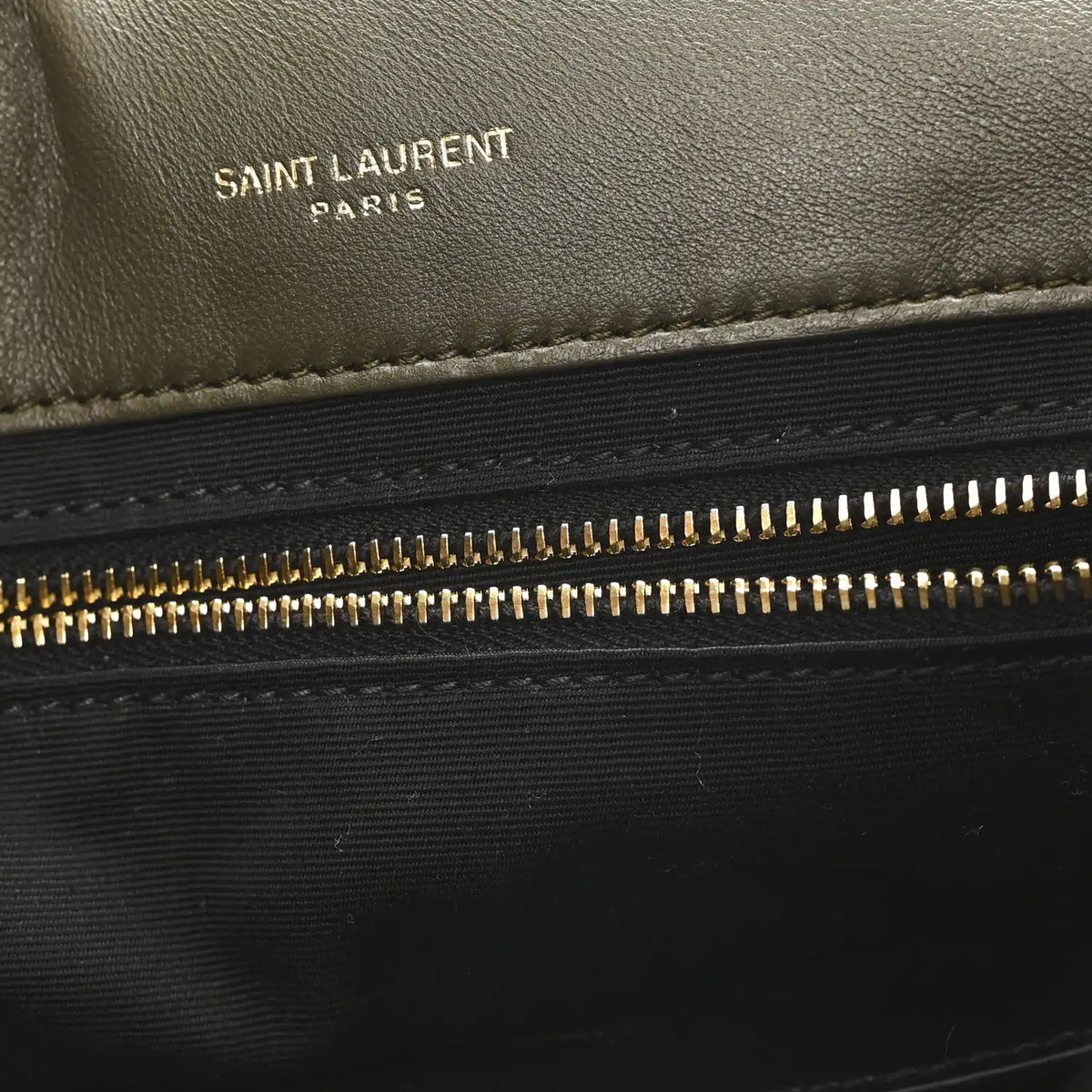 Black leather shearling bag panel with “SAINT LAURENT PARIS” text and zipper