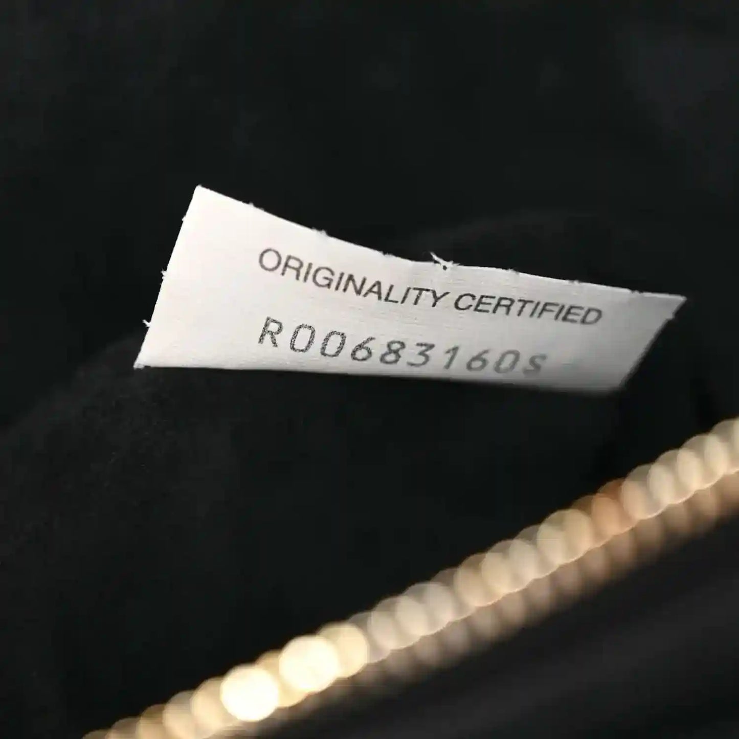 Black leather handbag with originality certified tag and serial number.