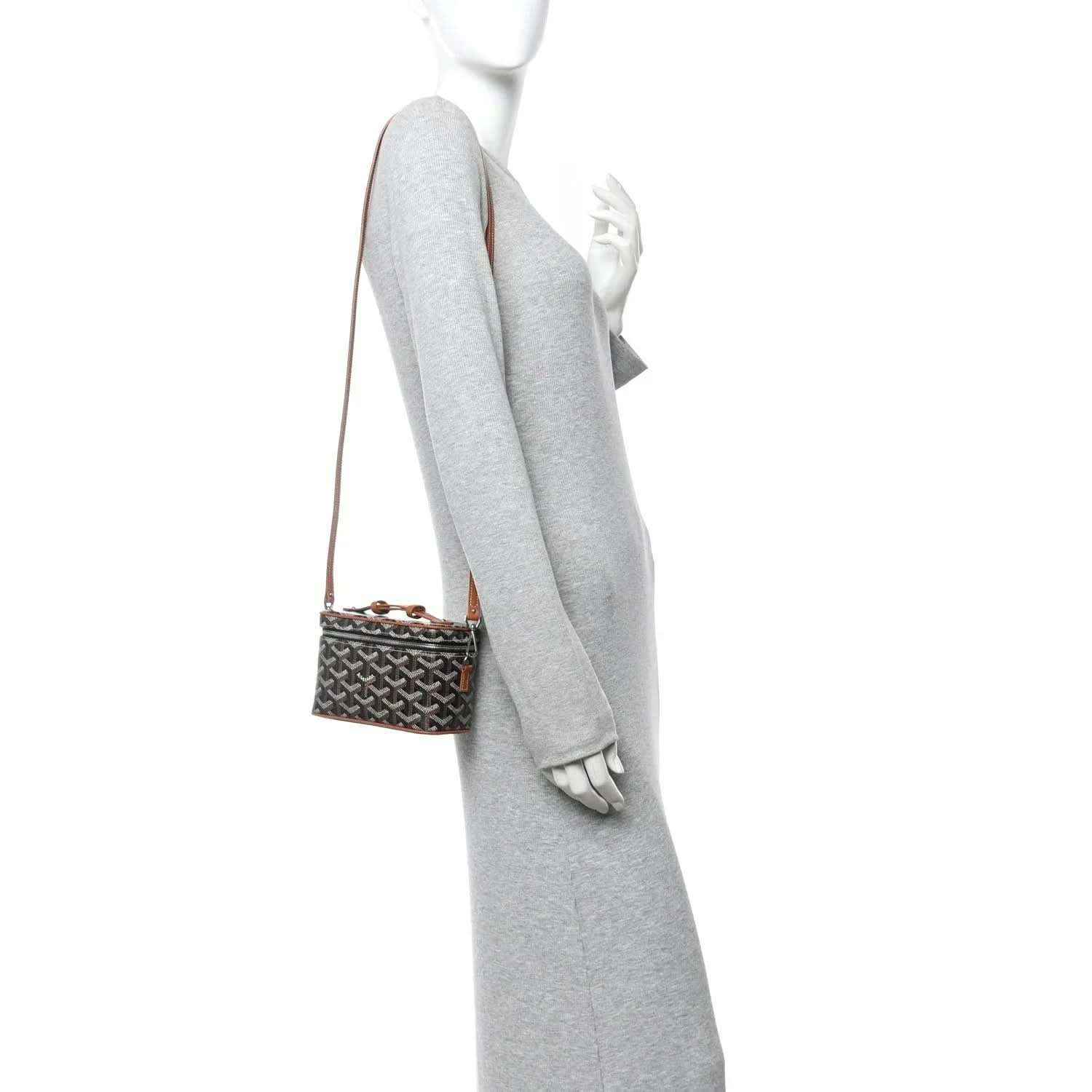 Mini vanity case worn crossbody; dark monogram canvas with tan leather strap and trim
