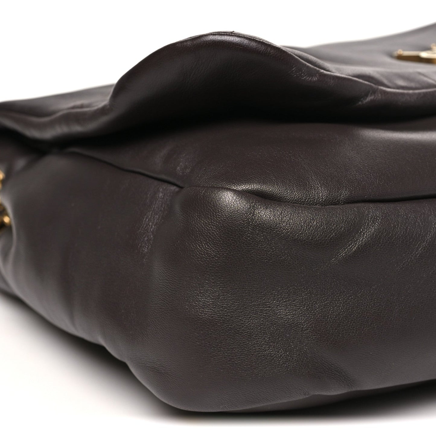 Curved quilted dark-brown leather shoulder bag exterior with visible stitched seams