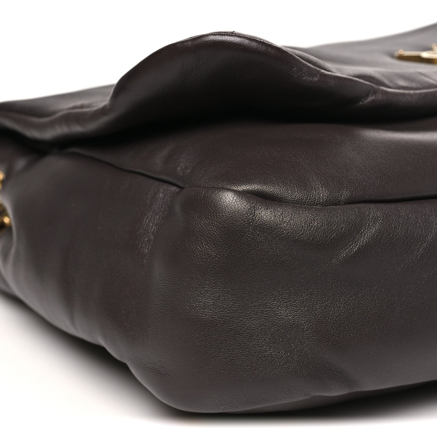 Curved quilted dark-brown leather shoulder bag exterior with visible stitched seams