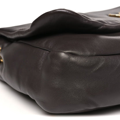 Curved quilted dark-brown leather shoulder bag exterior with visible stitched seams