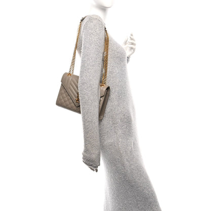 Dusty grey quilted satchel on shoulder with gold chain strap