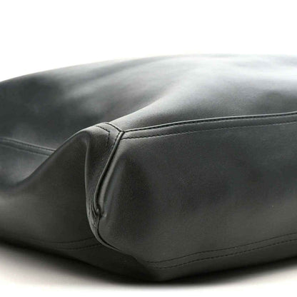 Black leather bag corner with stitched seam detail and rounded body shape