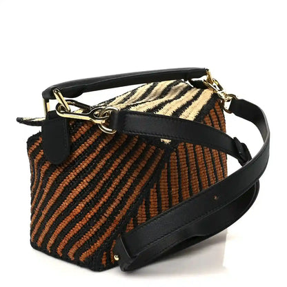 Small raffia puzzle bag with black leather top handle, striped natural and orange weave