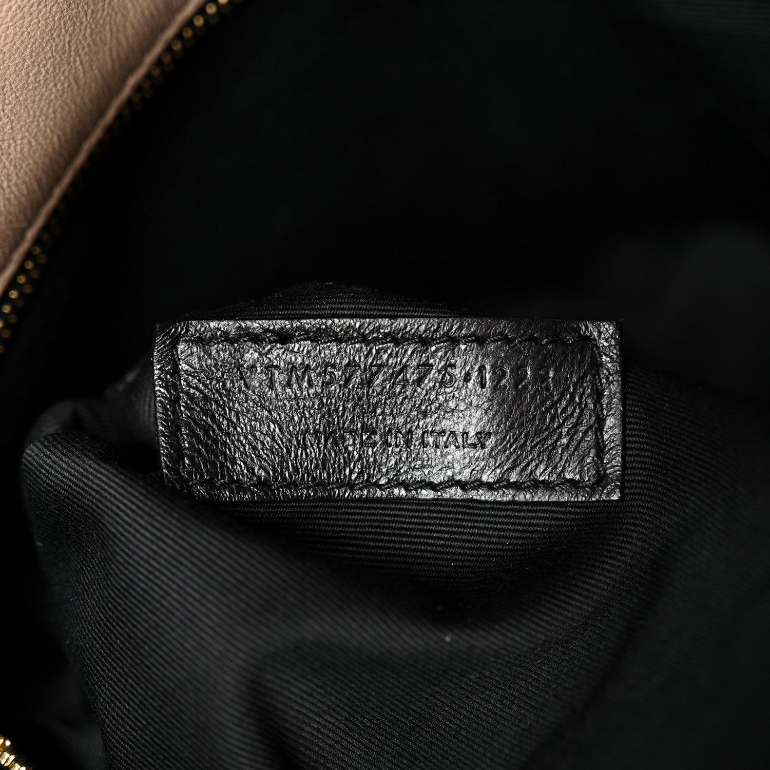 Black fabric label inside satchel interior near zipper lining
