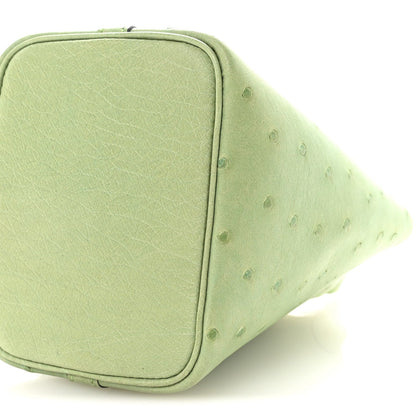 Green mini handbag side with textured leather and curved piping along the edge