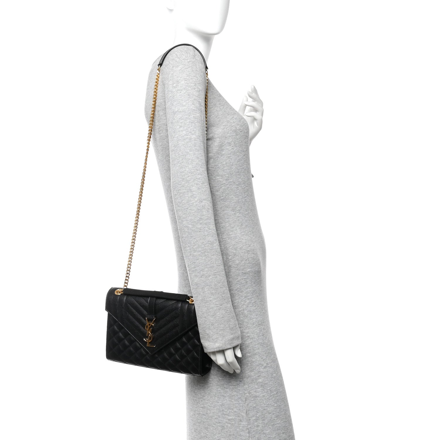 Black quilted mini satchel with flap closure and gold chain shoulder strap on a person