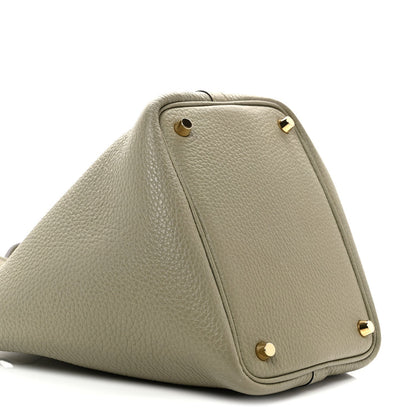 Sauge leather tote bag side view with front flap and gold rivet hardware