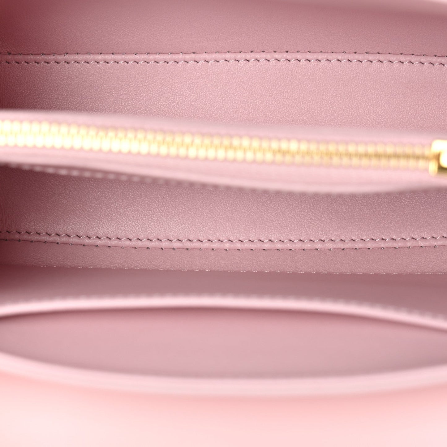 Pastel pink leather mini bag interior with gold zipper track and stitched lining