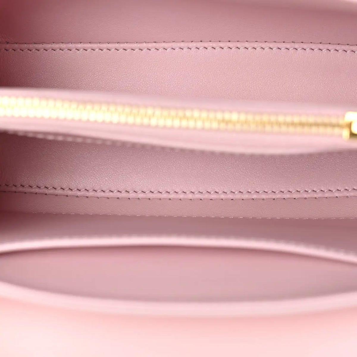 Pastel pink leather mini bag interior with gold zipper track and stitched lining
